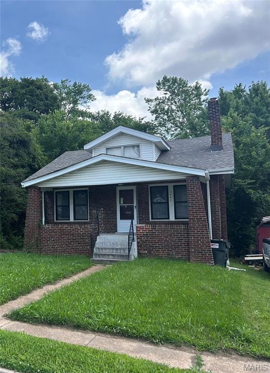 3442 Oakdale Ave, Saint Louis, MO 63121 - bungalow featuring brick siding, a chimney, a front lawn, and a porch