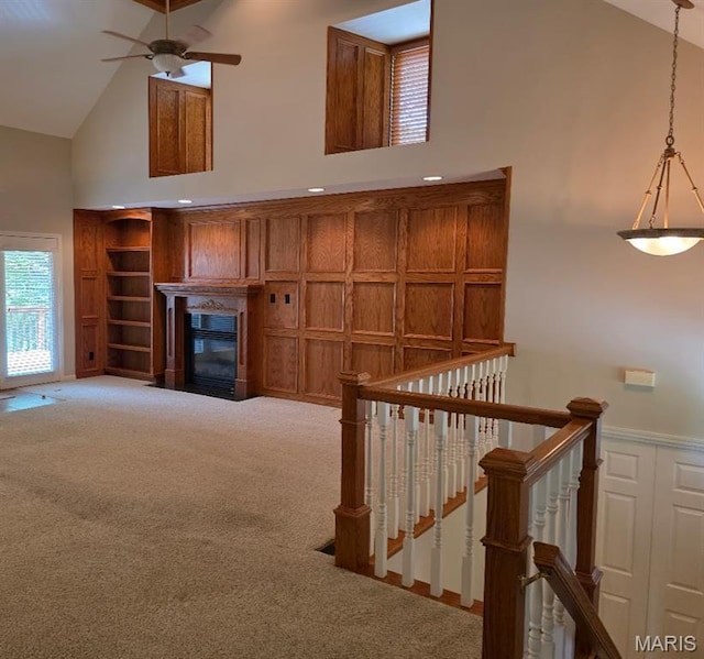 302 Lorean St, Troy, IL 62294 - staircase featuring high vaulted ceiling, carpet flooring, a ceiling fan, a glass covered fireplace, and wainscoting