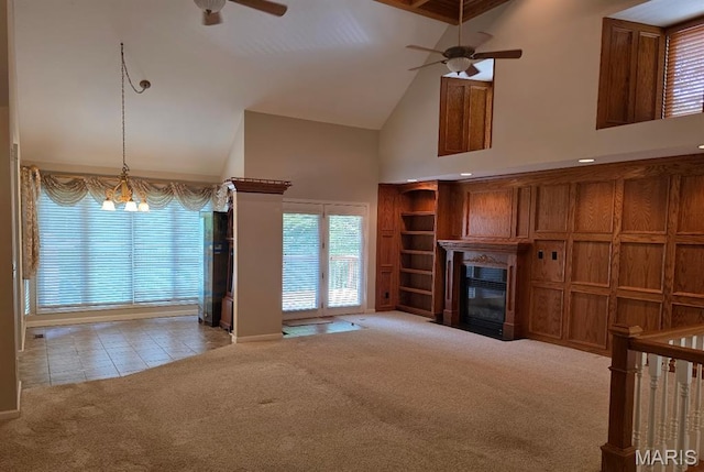 302 Lorean St, Troy, IL 62294 - unfurnished living room featuring ceiling fan, high vaulted ceiling, carpet, a glass covered fireplace, and tile patterned flooring