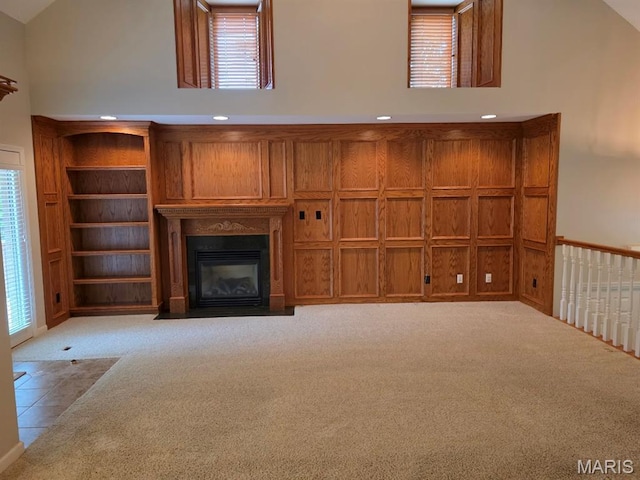302 Lorean St, Troy, IL 62294 - unfurnished living room featuring carpet flooring, high vaulted ceiling, plenty of natural light, and a fireplace with flush hearth
