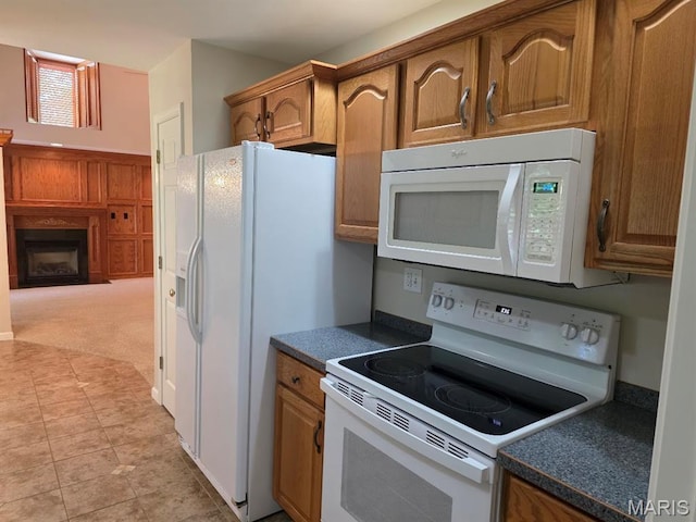 302 Lorean St, Troy, IL 62294 - kitchen featuring white appliances, dark countertops, a fireplace, and brown cabinetry