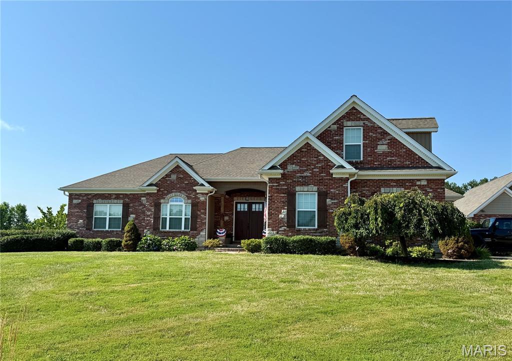 11078 Stonebridge Ln, Wentzville, MO 63385 - view of front of house featuring brick siding, a front lawn, and roof with shingles
