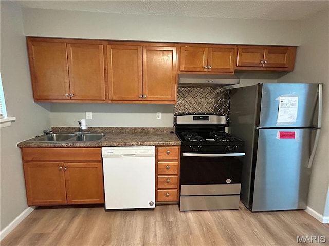 6023 Shillington Dr, Berkeley, MO 63134 - kitchen with stainless steel appliances, exhaust hood, brown cabinetry, and light wood-style floors