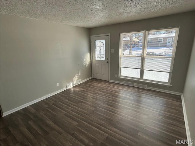 6023 Shillington Dr, Berkeley, MO 63134 - foyer entrance featuring a textured ceiling and dark wood-style flooring