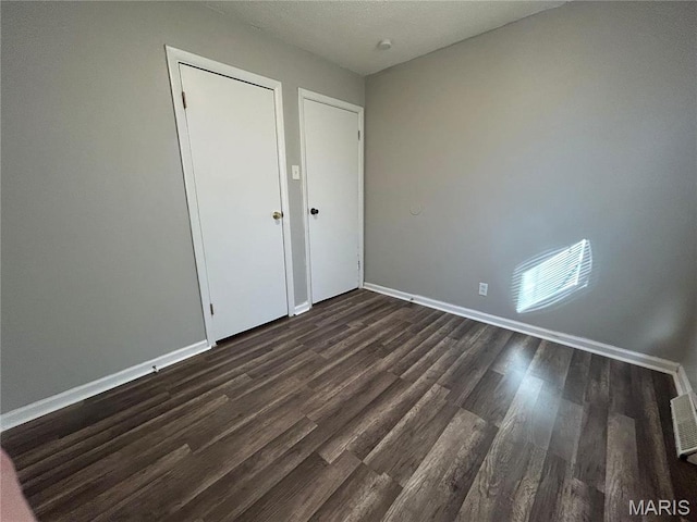 6023 Shillington Dr, Berkeley, MO 63134 - unfurnished bedroom with dark wood-style floors and baseboards