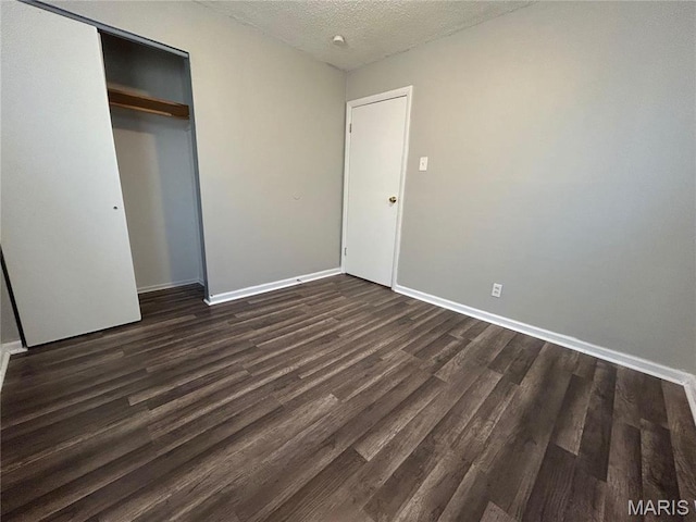 6023 Shillington Dr, Berkeley, MO 63134 - unfurnished bedroom featuring dark wood-style flooring, a textured ceiling, and a closet