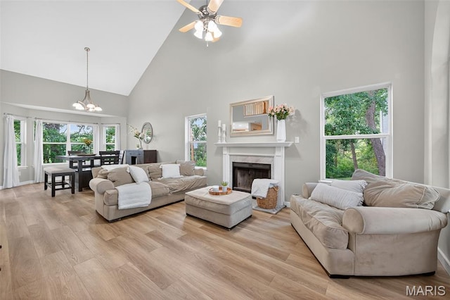 794 Buckboard Ln, Fenton, MO 63026 - living room featuring high vaulted ceiling, a fireplace, a chandelier, light wood-type flooring, and plenty of natural light