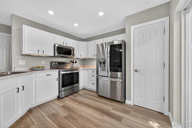 794 Buckboard Ln, Fenton, MO 63026 - kitchen with appliances with stainless steel finishes, light wood-style floors, white cabinets, recessed lighting, and light countertops