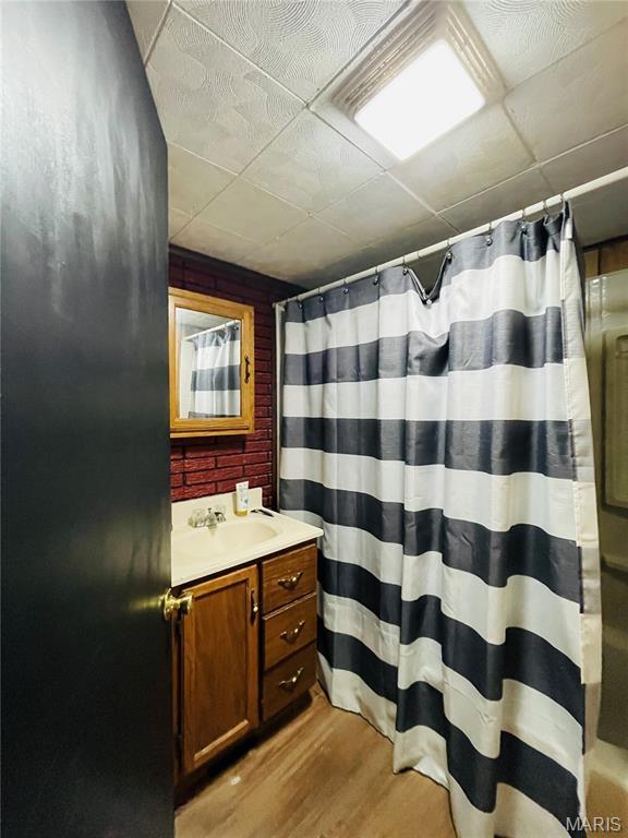 628 Valley View Dr, Bethalto, IL 62010 - bathroom with wood finished floors, vanity, a shower with curtain, and a paneled ceiling