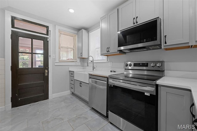8260 Glen Echo Dr, Bel-Nor, MO 63121 - kitchen with appliances with stainless steel finishes, gray cabinetry, recessed lighting, light stone counters, and light marble finish floors