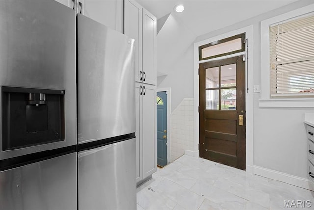 8260 Glen Echo Dr, Bel-Nor, MO 63121 - kitchen featuring stainless steel refrigerator with ice dispenser, white cabinets, recessed lighting, tile walls, and vaulted ceiling