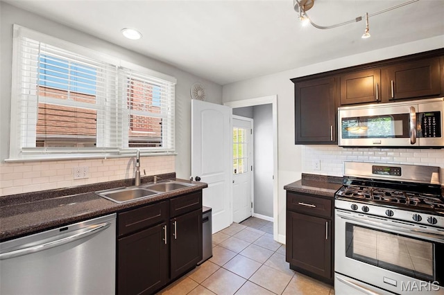 6915 Wise Ave, Saint Louis, MO 63139 - kitchen featuring stainless steel appliances, dark countertops, dark brown cabinetry, light tile patterned floors, and tasteful backsplash