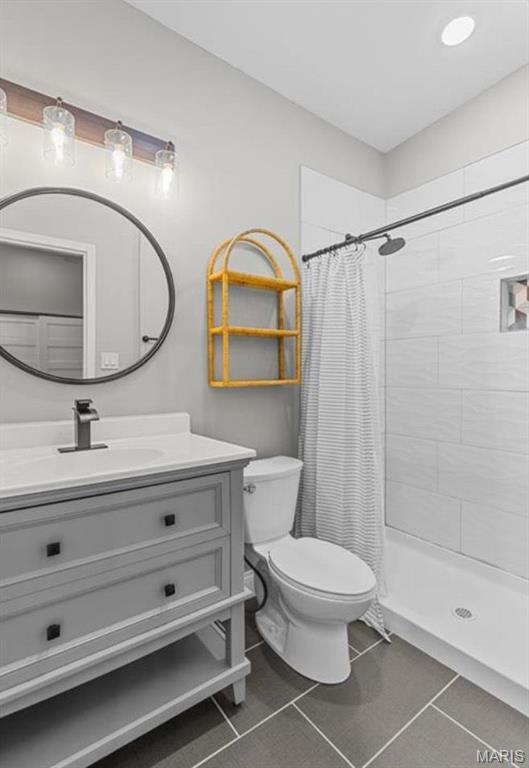 4355 Hunt Ave, Saint Louis, MO 63110 - bathroom featuring vanity, tiled shower, and tile patterned flooring