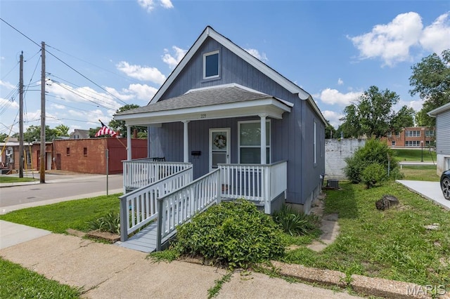 229 Broadway Ave, Crystal City, MO 63019 - view of front of home with covered porch, roof with shingles, and a front yard