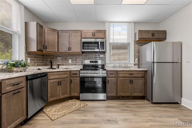 229 Broadway Ave, Crystal City, MO 63019 - kitchen with appliances with stainless steel finishes, tasteful backsplash, light wood finished floors, and light stone countertops