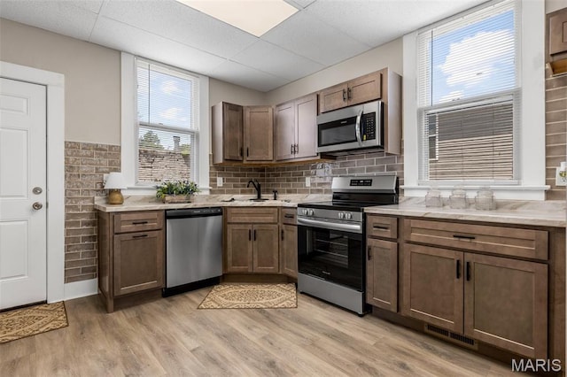 229 Broadway Ave, Crystal City, MO 63019 - kitchen with appliances with stainless steel finishes, light wood-type flooring, tasteful backsplash, and a drop ceiling