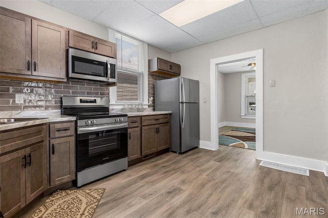 229 Broadway Ave, Crystal City, MO 63019 - kitchen featuring stainless steel appliances, a drop ceiling, tasteful backsplash, light wood-style flooring, and ceiling fan