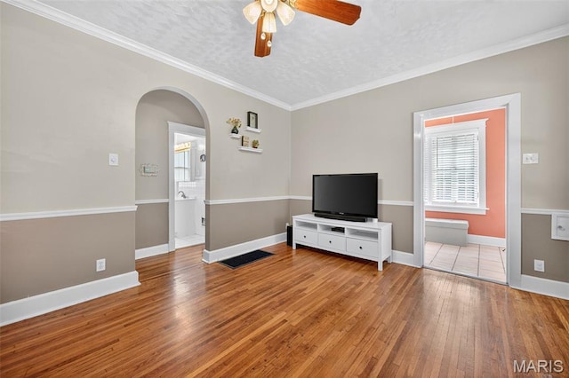 5965 S Cuba Ct, Saint Louis, MO 63139 - unfurnished living room with a ceiling fan, hardwood / wood-style flooring, arched walkways, a textured ceiling, and ornamental molding