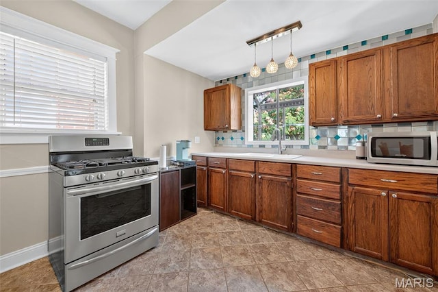 5965 S Cuba Ct, Saint Louis, MO 63139 - kitchen with stainless steel appliances, brown cabinets, tasteful backsplash, and light countertops