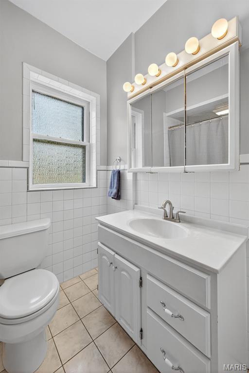 5965 S Cuba Ct, Saint Louis, MO 63139 - full bath with tile walls, vanity, tile patterned floors, and wainscoting