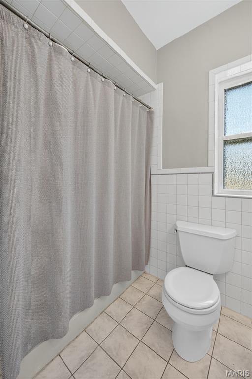 5965 S Cuba Ct, Saint Louis, MO 63139 - full bathroom with tile patterned floors, tile walls, and wainscoting