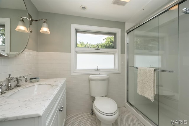 444 Algonquin Pl, Webster Groves, MO 63119 - full bathroom with tile walls, vanity, a wainscoted wall, a shower stall, and tile patterned floors
