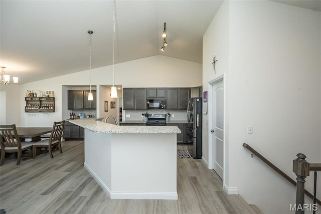 229 Essex Ct, Wright City, MO 63390 - kitchen featuring black microwave, range with electric stovetop, vaulted ceiling, light wood-style floors, and stainless steel fridge