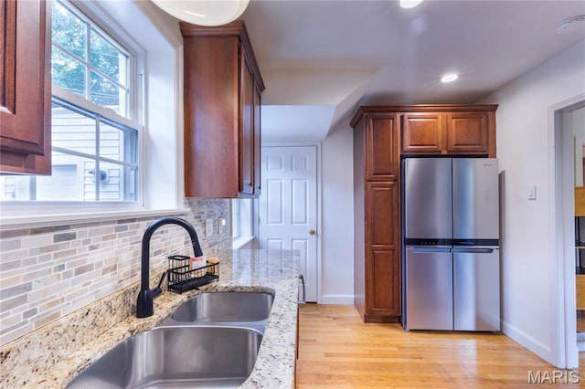 1076 N Jackson Ave, University City, MO 63130 - kitchen with freestanding refrigerator, tasteful backsplash, light stone counters, light wood-type flooring, and recessed lighting