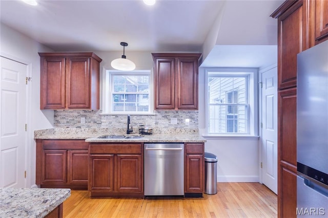 1076 N Jackson Ave, University City, MO 63130 - kitchen featuring appliances with stainless steel finishes, light wood-type flooring, tasteful backsplash, and light stone counters