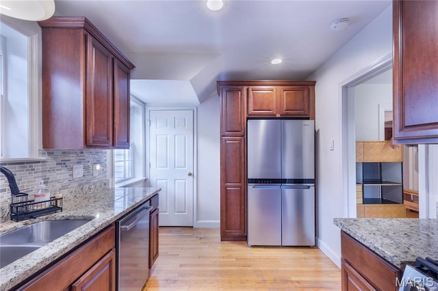 1076 N Jackson Ave, University City, MO 63130 - kitchen featuring appliances with stainless steel finishes, light wood-style flooring, decorative backsplash, recessed lighting, and light stone countertops