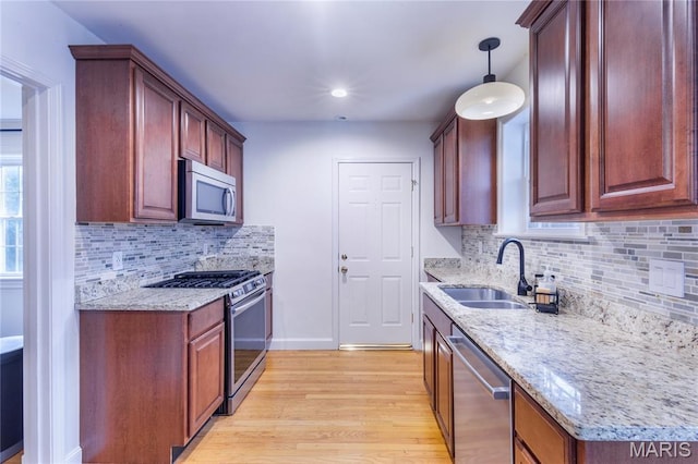 1076 N Jackson Ave, University City, MO 63130 - kitchen featuring appliances with stainless steel finishes, light wood-type flooring, light stone countertops, backsplash, and recessed lighting