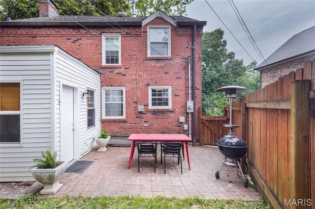 1076 N Jackson Ave, University City, MO 63130 - rear view of house with a gate, brick siding, and a patio area