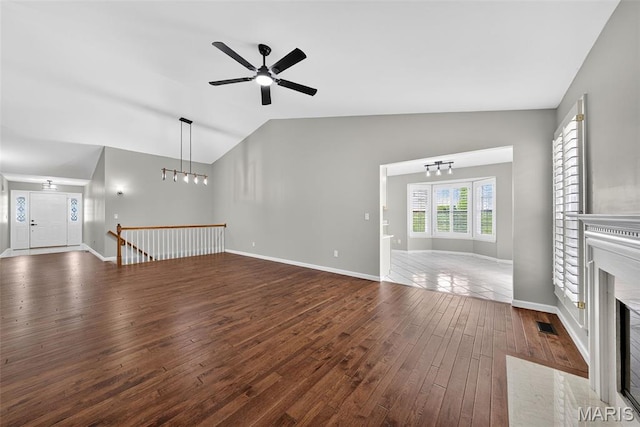 2417 S Lakeridge Ct Unit 14, Lake St Louis, MO 63367 - unfurnished living room with lofted ceiling, dark wood-type flooring, a ceiling fan, and a fireplace with flush hearth