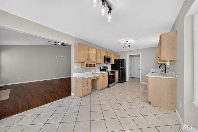 2417 S Lakeridge Ct Unit 14, Lake St Louis, MO 63367 - kitchen with light brown cabinetry, stainless steel appliances, light countertops, and light tile patterned floors