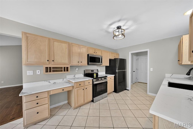 2417 S Lakeridge Ct Unit 14, Lake St Louis, MO 63367 - kitchen with light brown cabinets, appliances with stainless steel finishes, light tile patterned flooring, built in study area, and light stone countertops