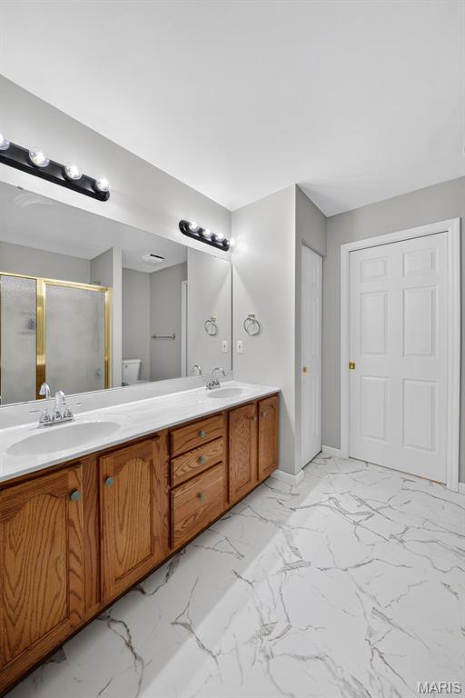 2417 S Lakeridge Ct Unit 14, Lake St Louis, MO 63367 - full bath featuring marble finish flooring, a shower stall, and double vanity