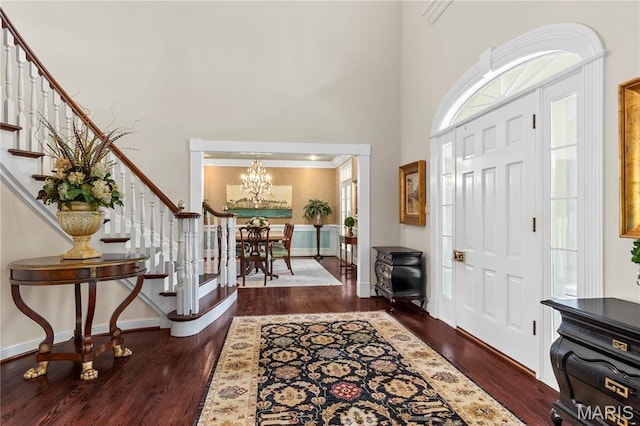 10420 Litzsinger Rd, Frontenac, MO 63131 - foyer entrance with stairs, a chandelier, a high ceiling, wood finished floors, and ornamental molding