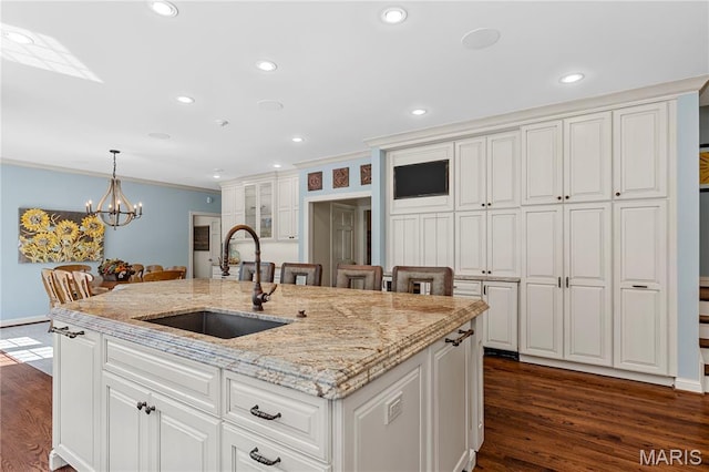 10420 Litzsinger Rd, Frontenac, MO 63131 - kitchen with crown molding, white cabinetry, decorative light fixtures, an island with sink, and a chandelier
