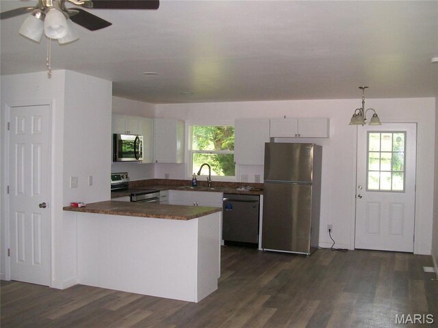 243 Jones St, Sullivan, MO 63080 - kitchen with stainless steel appliances, dark countertops, a peninsula, and dark wood finished floors