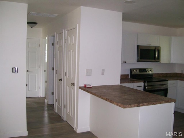 243 Jones St, Sullivan, MO 63080 - kitchen featuring appliances with stainless steel finishes, dark wood-style floors, dark countertops, and white cabinets