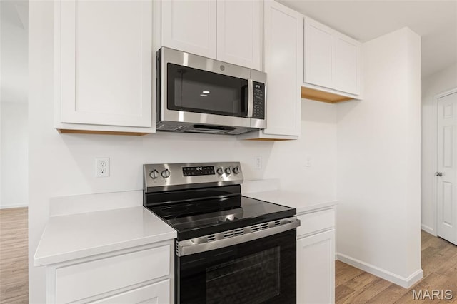 347 Heather Mill Dr, Wentzville, MO 63385 - kitchen with stainless steel appliances, light wood-style flooring, light countertops, and white cabinetry