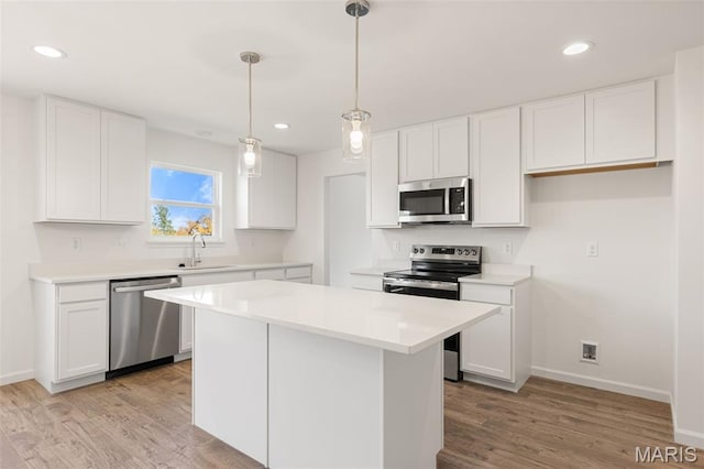 347 Heather Mill Dr, Wentzville, MO 63385 - kitchen featuring stainless steel appliances, white cabinetry, light wood-style floors, and recessed lighting