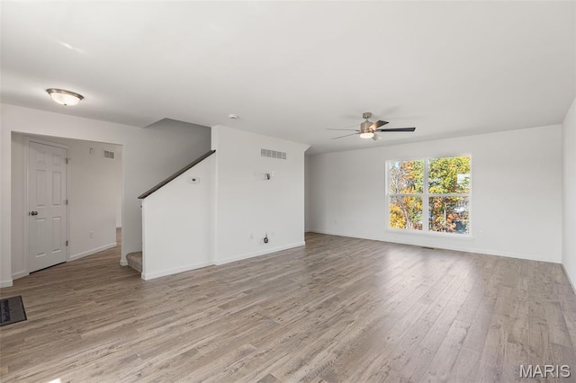 347 Heather Mill Dr, Wentzville, MO 63385 - spare room featuring light wood-style flooring, a ceiling fan, and stairs