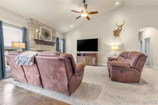 222 Austin Oaks Dr, Moscow Mills, MO 63362 - living room with lofted ceiling, arched walkways, healthy amount of natural light, ceiling fan, and a fireplace