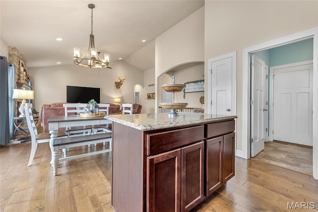 222 Austin Oaks Dr, Moscow Mills, MO 63362 - kitchen featuring lofted ceiling, light wood finished floors, a chandelier, open floor plan, and hanging light fixtures