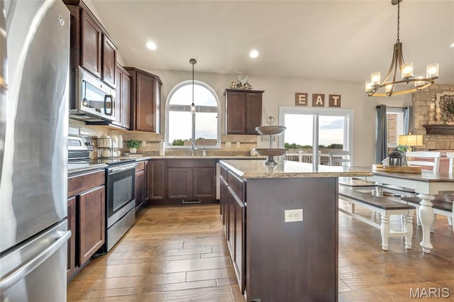 222 Austin Oaks Dr, Moscow Mills, MO 63362 - kitchen featuring appliances with stainless steel finishes, a chandelier, wood-type flooring, a kitchen island, and recessed lighting