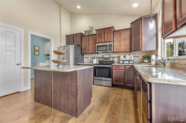 222 Austin Oaks Dr, Moscow Mills, MO 63362 - kitchen featuring appliances with stainless steel finishes, high vaulted ceiling, tasteful backsplash, light stone counters, and dark wood-style floors
