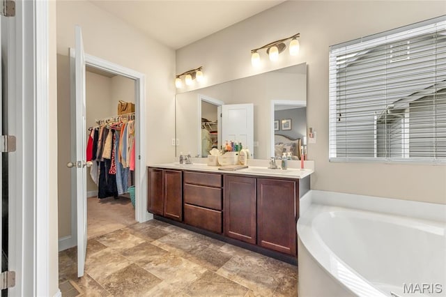222 Austin Oaks Dr, Moscow Mills, MO 63362 - bathroom featuring a walk in closet, a garden tub, and double vanity
