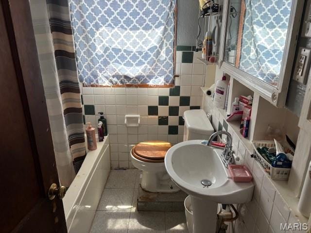 929 Lake St, Sikeston, MO 63801 - full bath featuring tile walls, tile patterned floors, healthy amount of natural light, and wainscoting