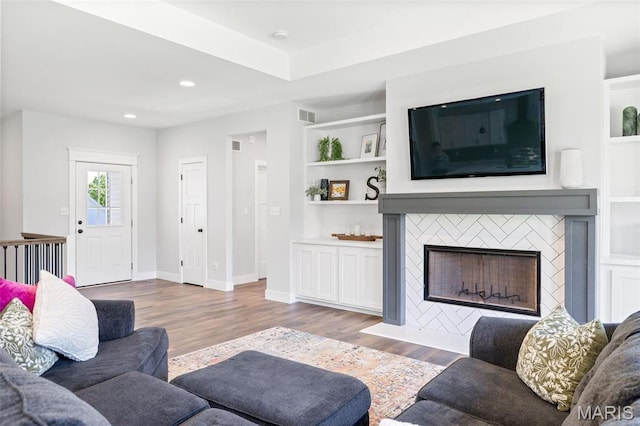10523 Village Ln, Foristell, MO 63348 - living area with wood finished floors, a tile fireplace, recessed lighting, and built in shelves